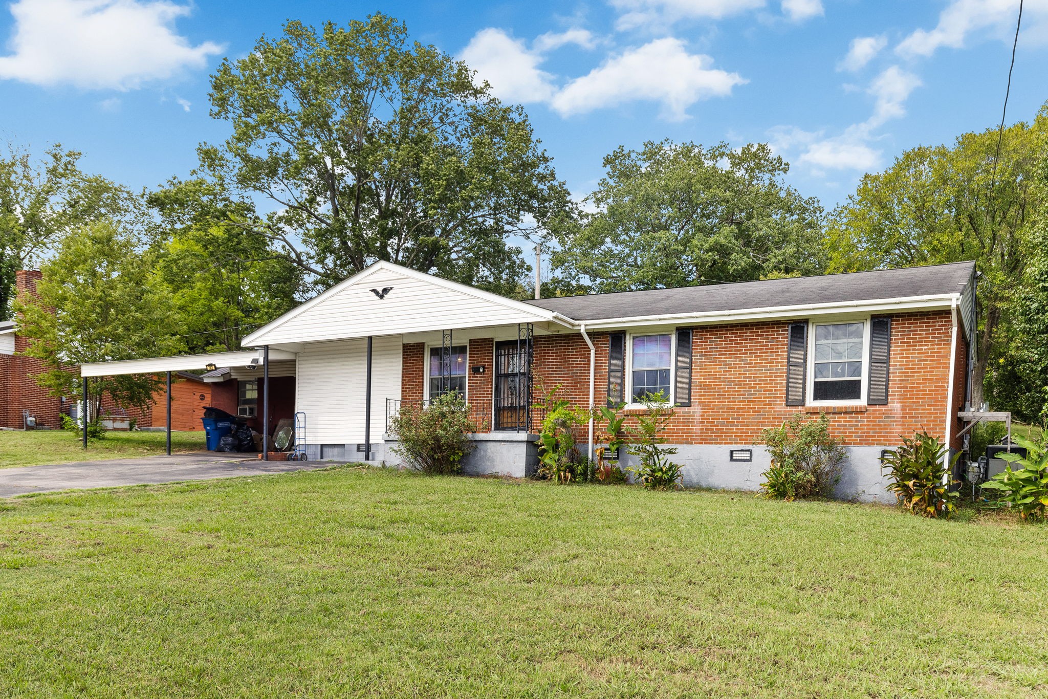 a front view of a house with a yard and trees