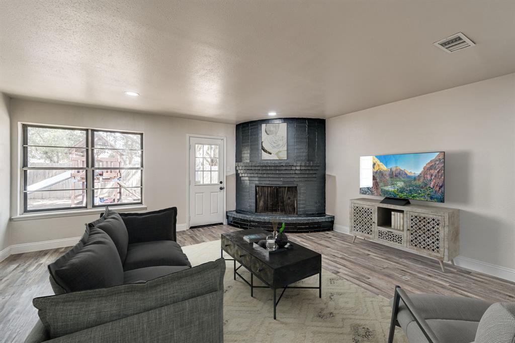 a living room with furniture a flat screen tv and a fireplace