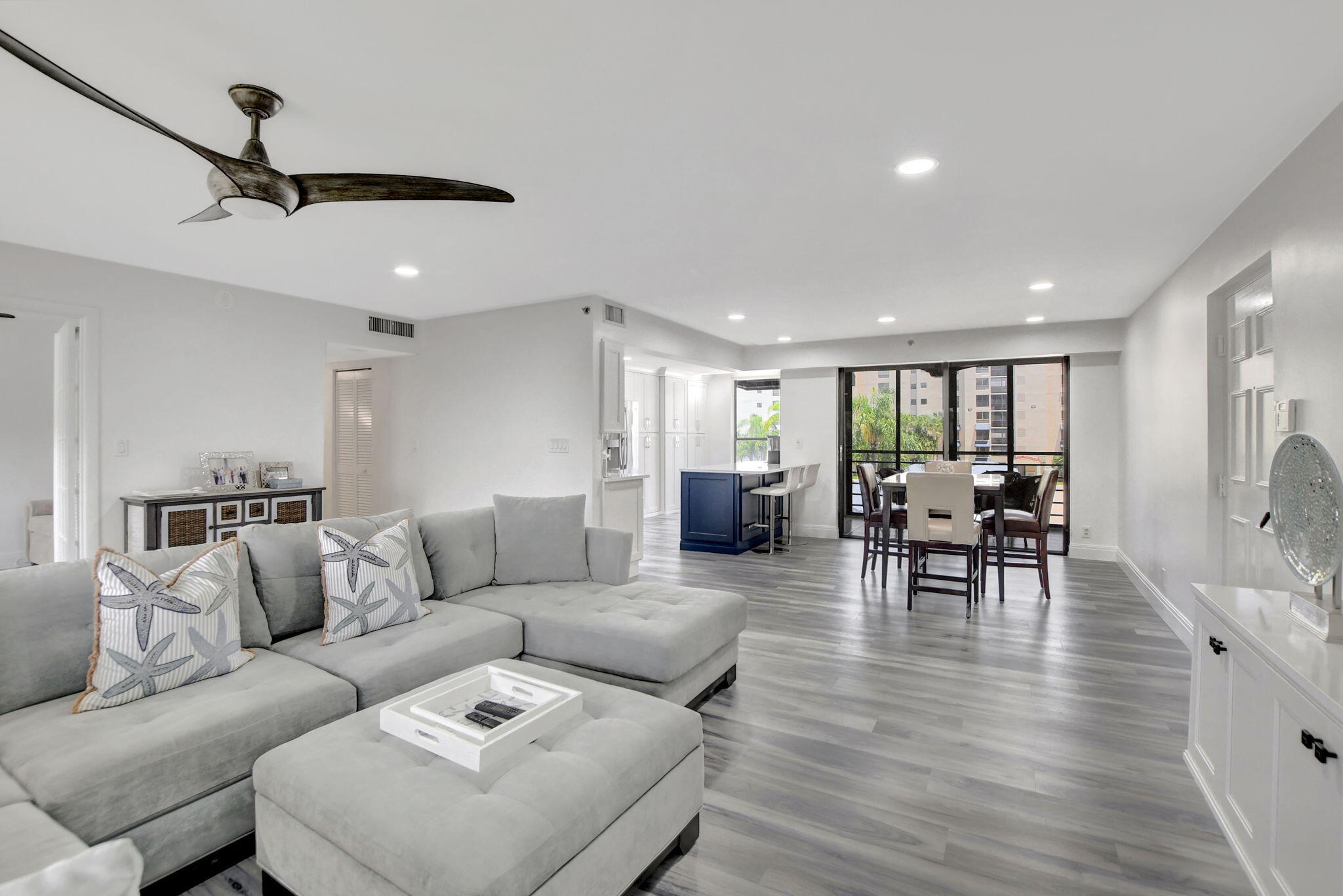 a living room with furniture and a dining table with wooden floor