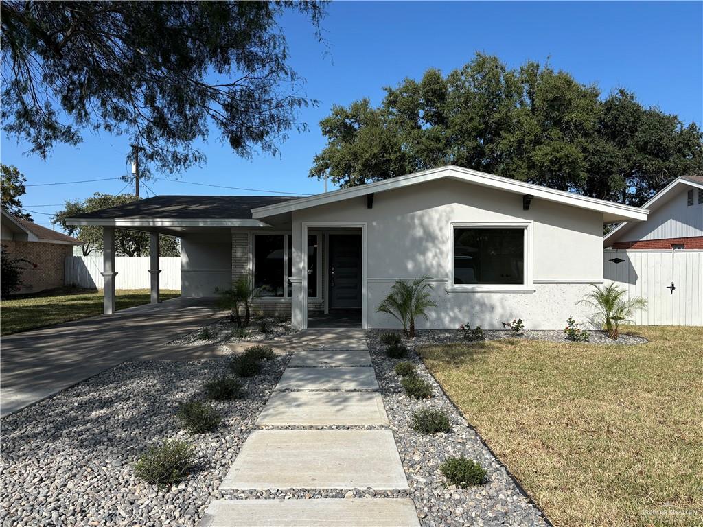 Single story home with a carport and a front lawn