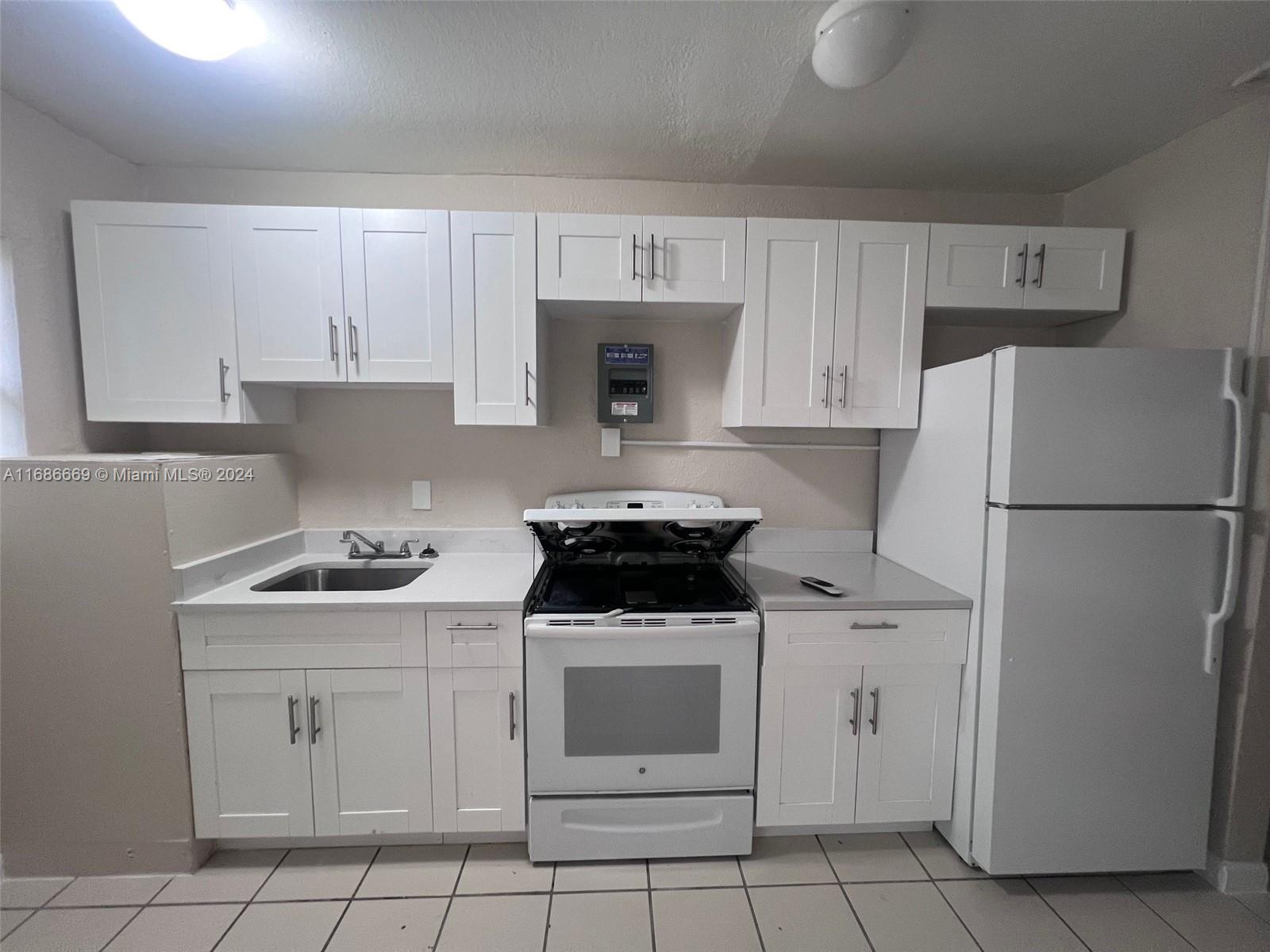 a kitchen with white cabinets and appliances