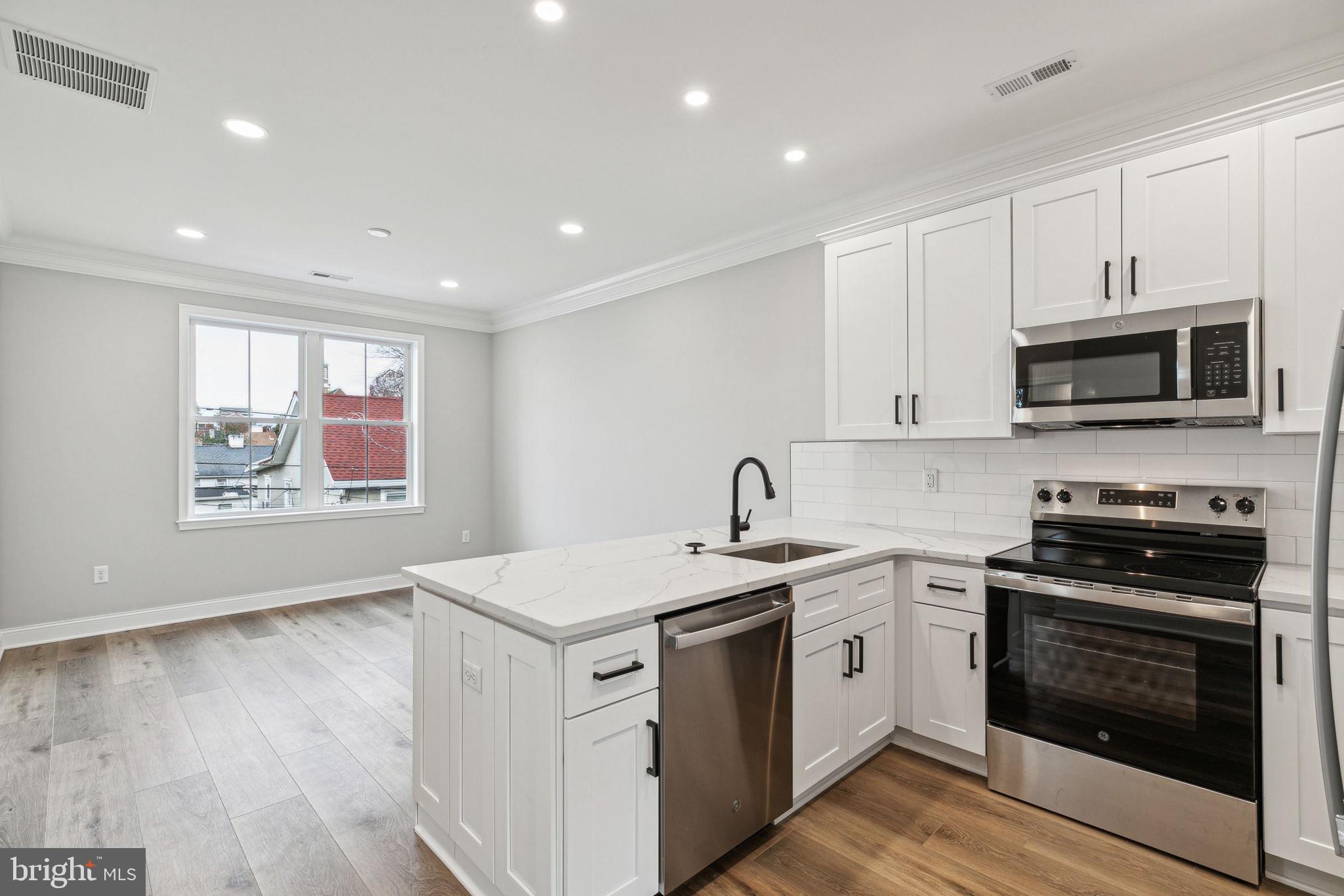 a kitchen with stainless steel appliances a stove microwave and sink