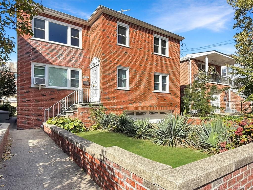 View of front of property featuring a garage and a balcony