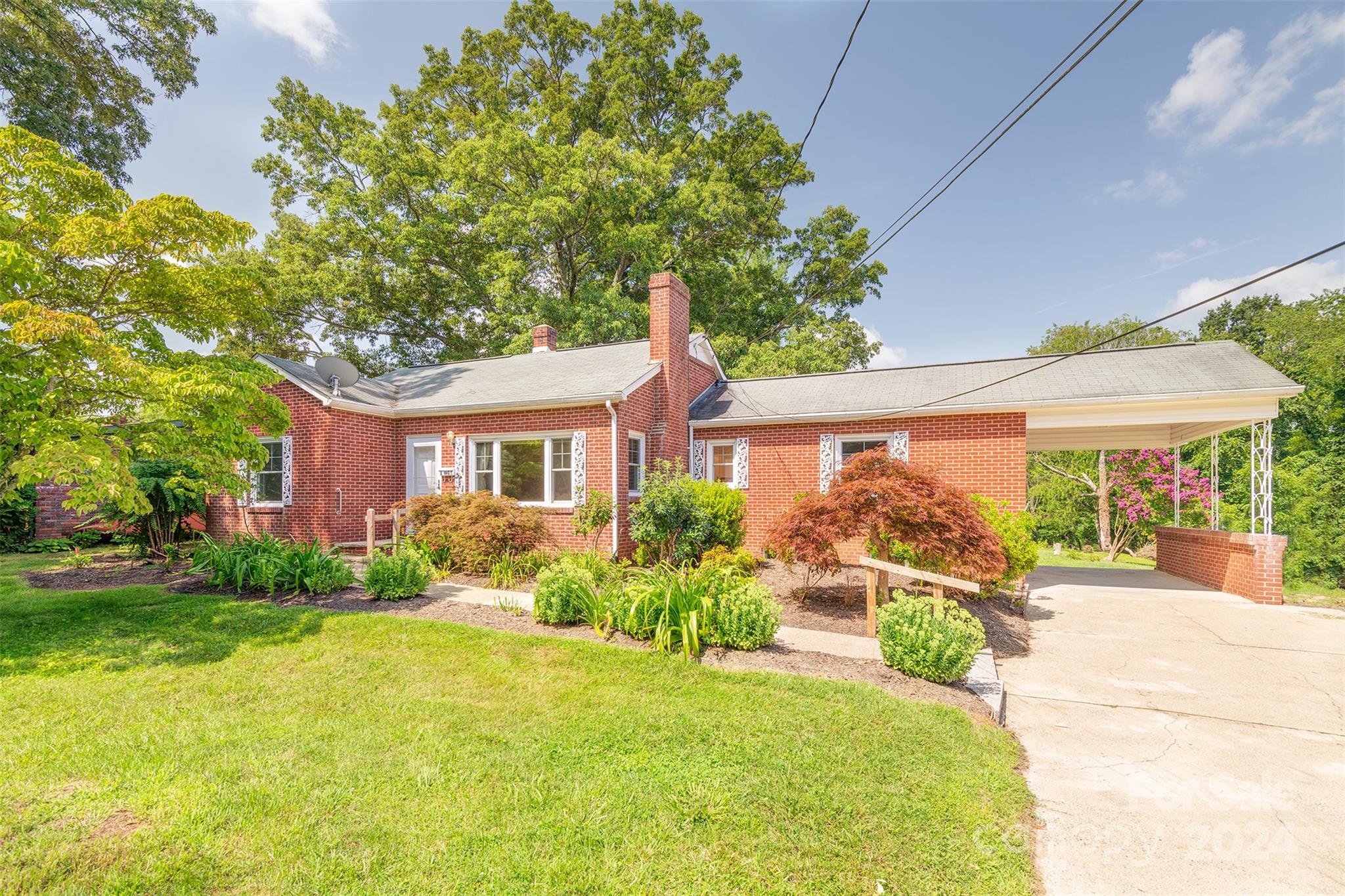 a front view of a house with a yard and potted plants