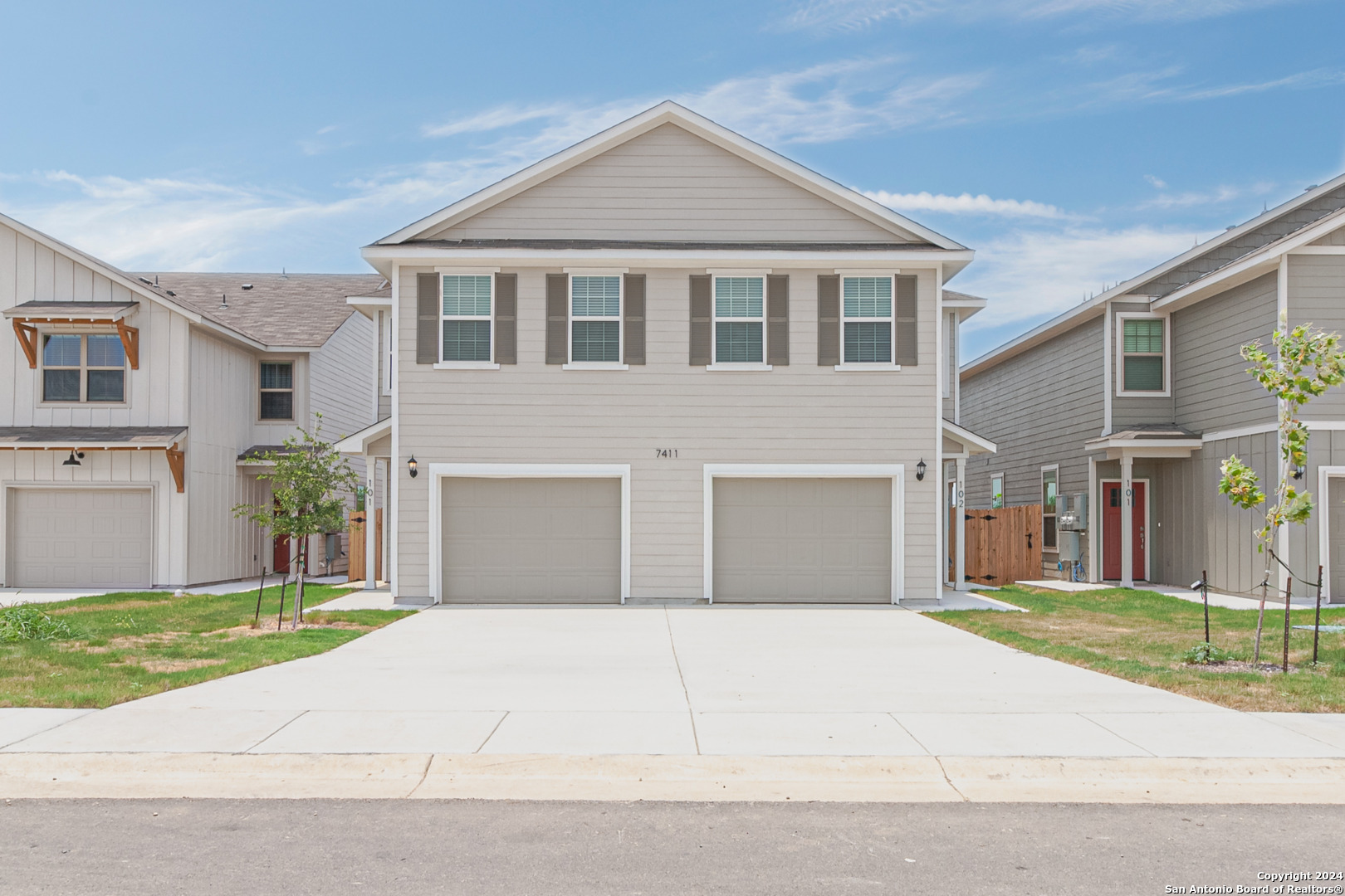 a front view of a house with a garden and garage