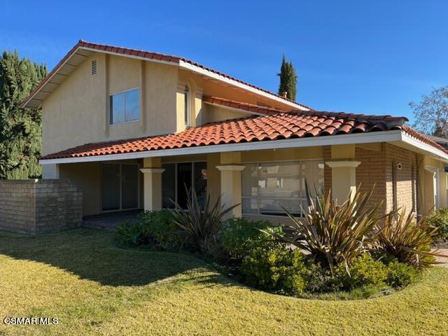 a front view of a house with plants