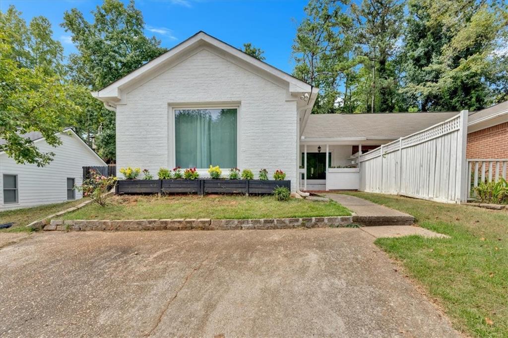 a view of house with backyard and trees