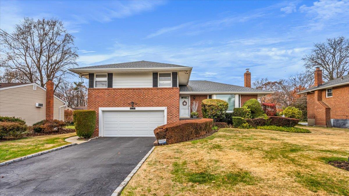 Split level home featuring a front yard and a garage