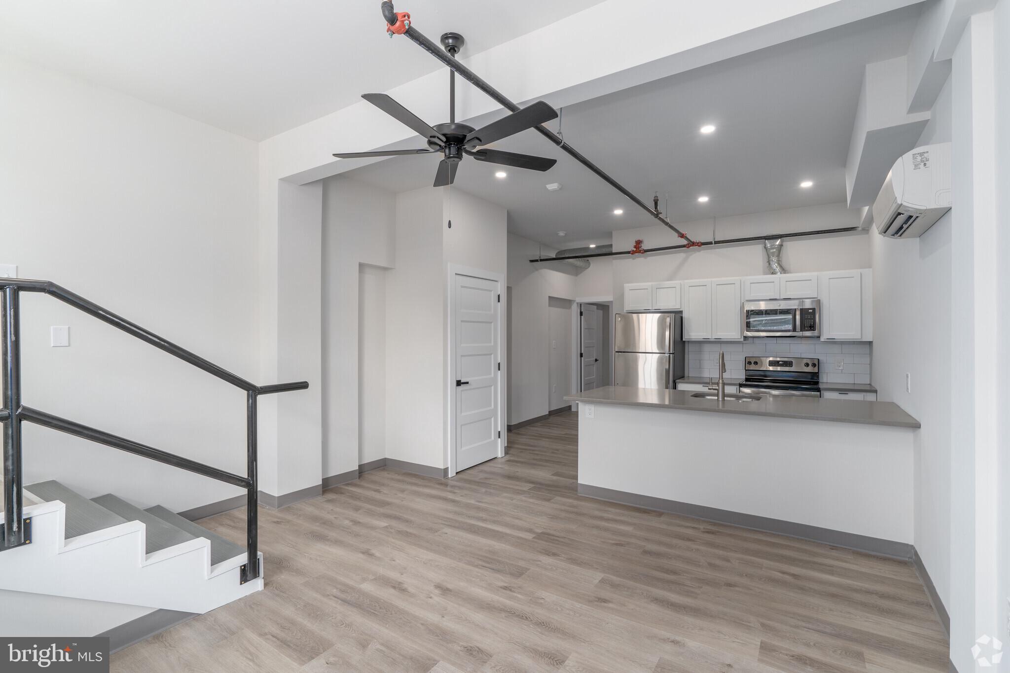 a kitchen with stainless steel appliances kitchen island in the center and wooden floor