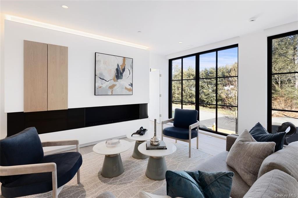 a living room with furniture and floor to ceiling windows