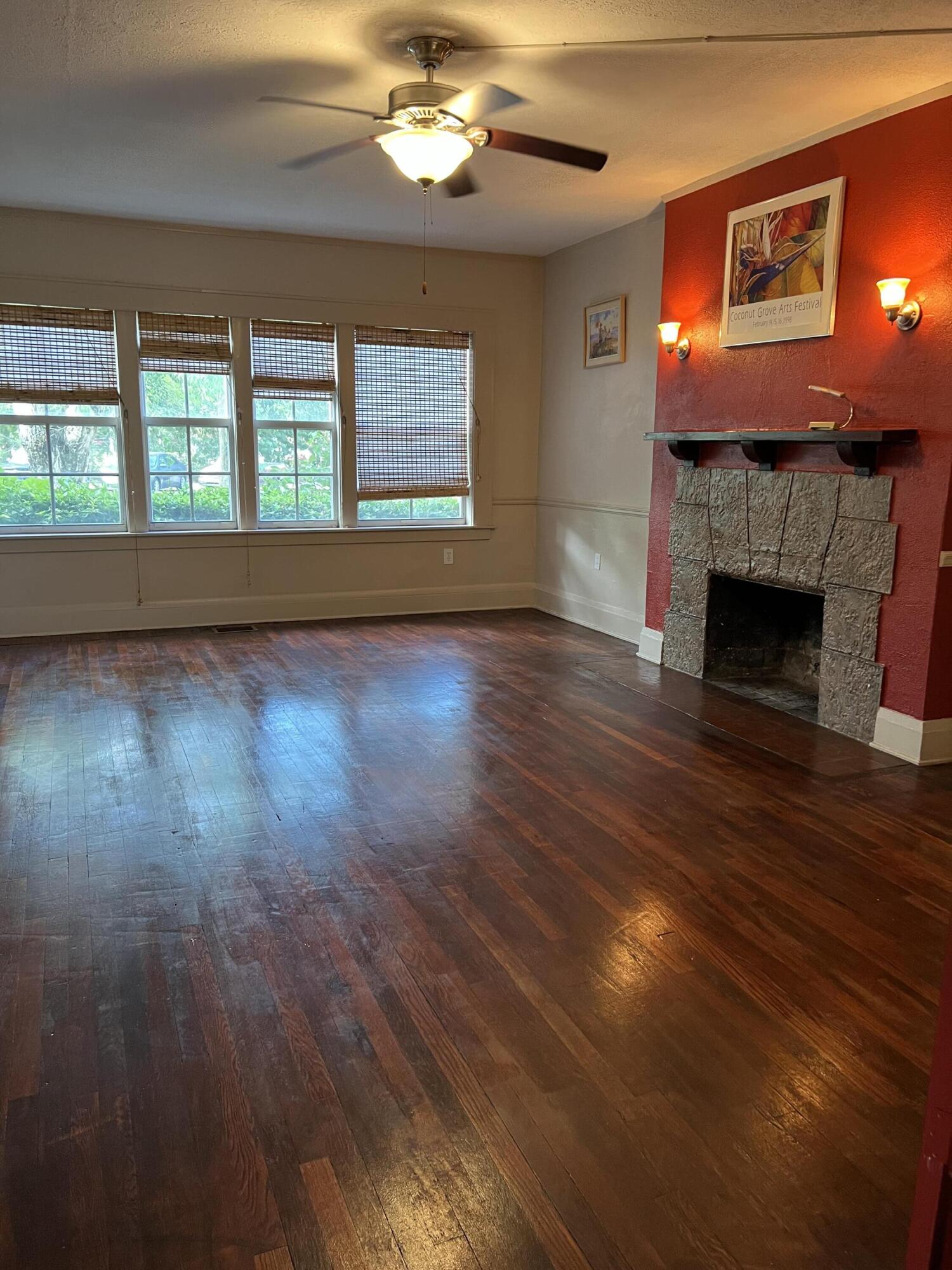 a view of empty room with wooden floor and fireplace