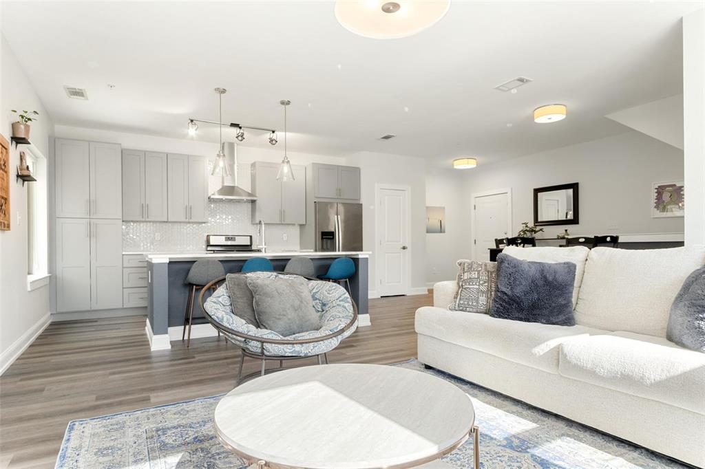 a living room with stainless steel appliances furniture a kitchen view and a kitchen view