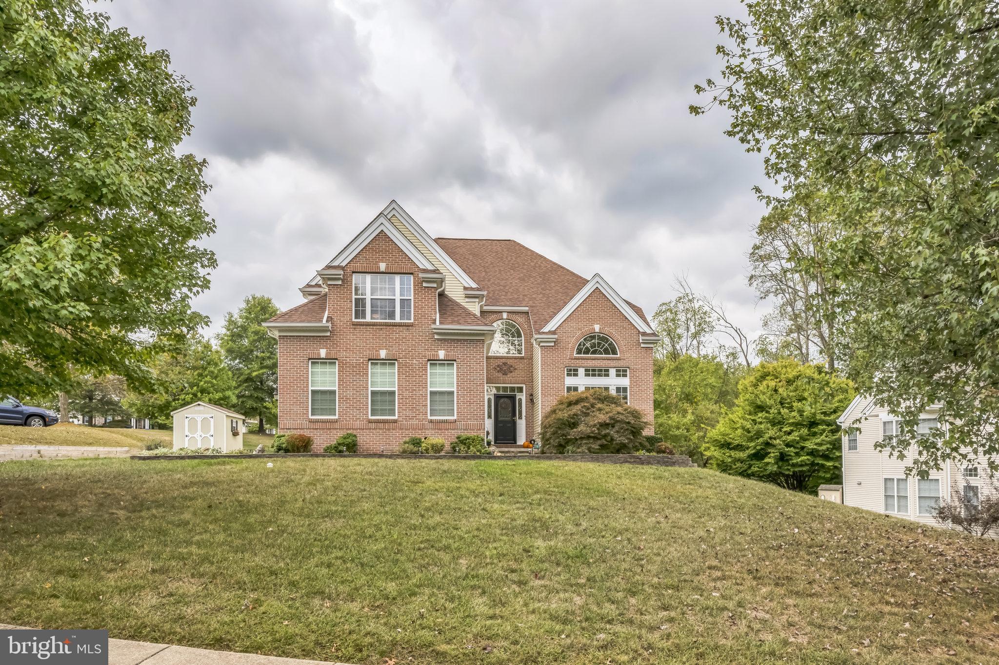 a view of a big house with a big yard and large trees