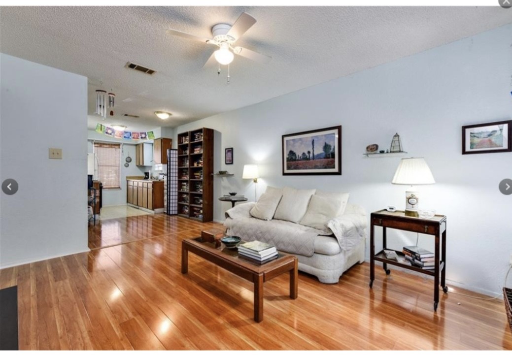 a living room with furniture a ceiling fan and a rug