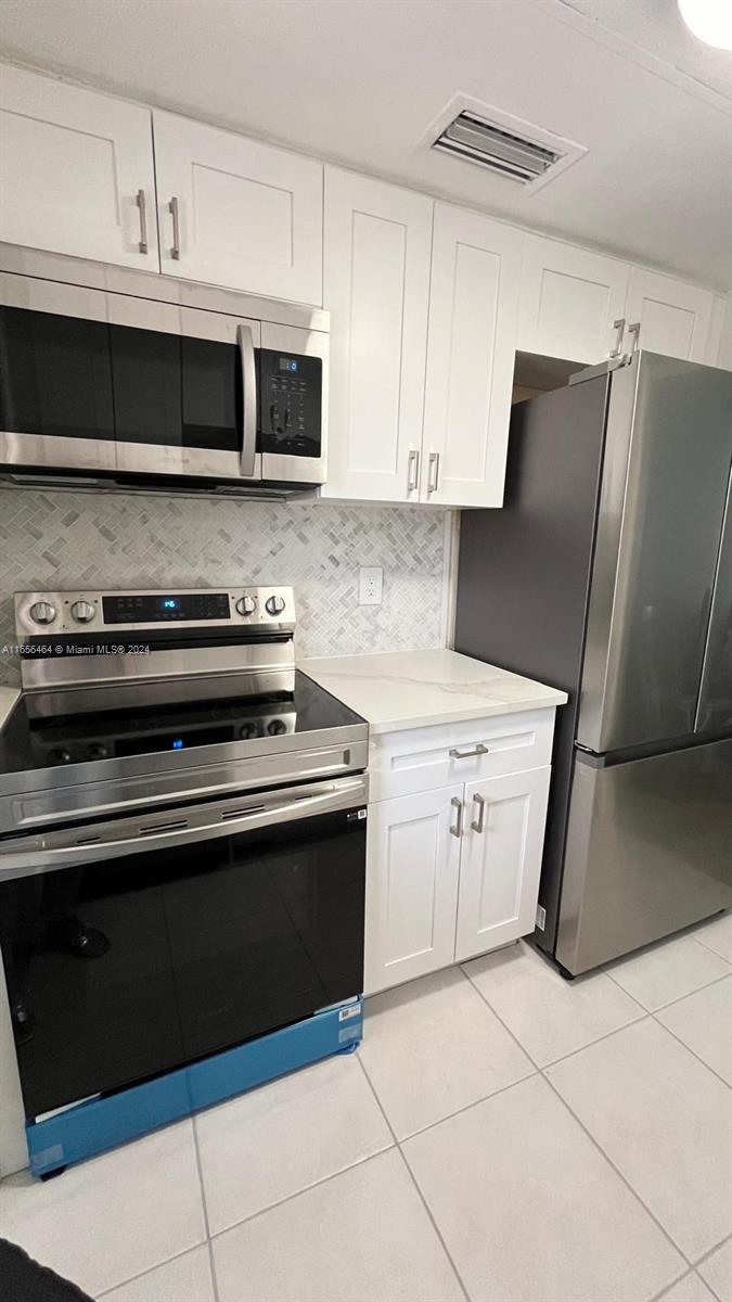 a kitchen with cabinets and steel stainless steel appliances