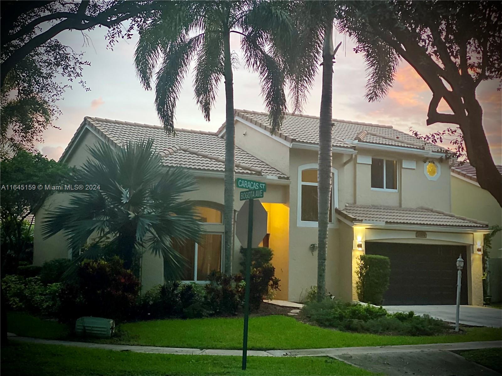 a front view of a house with yard and green space