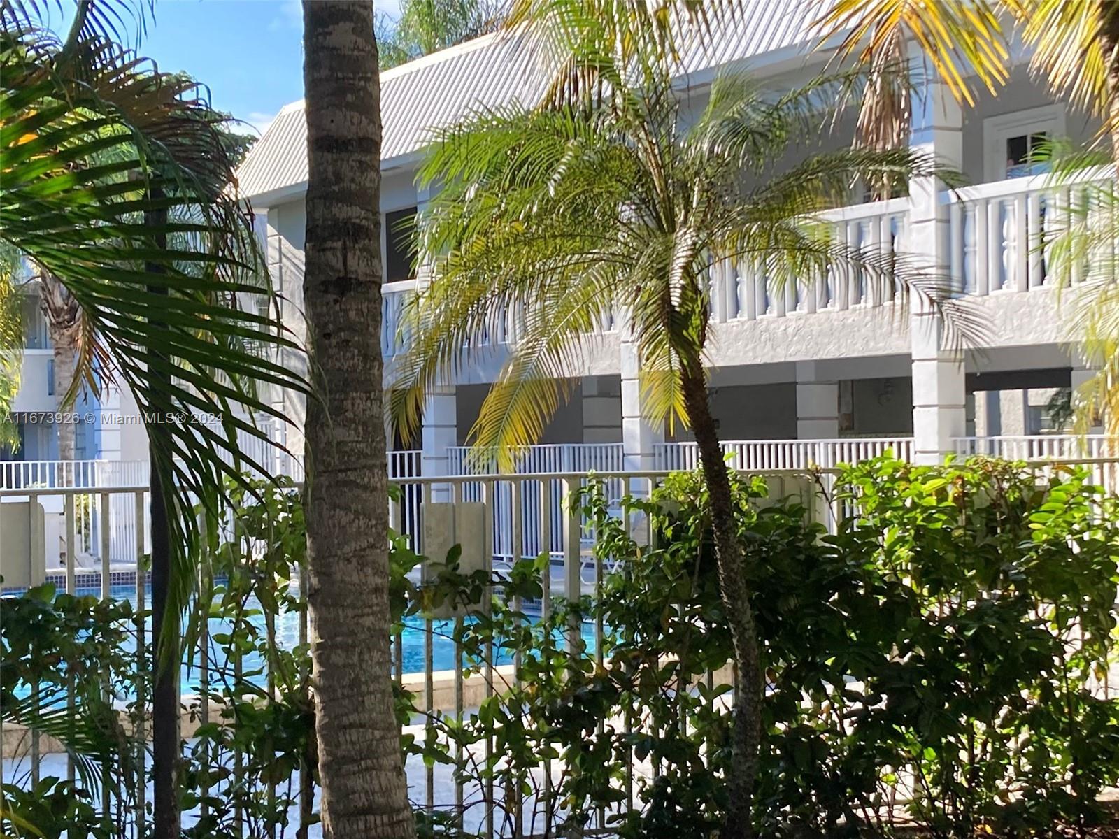 a front view of a multi story residential apartment building with a yard and balcony