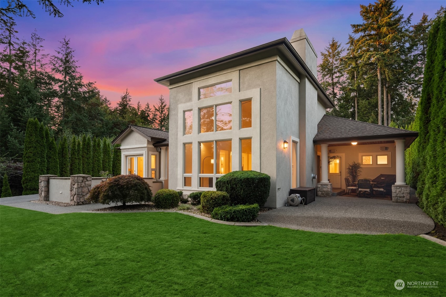 a front view of a house with a yard and trees