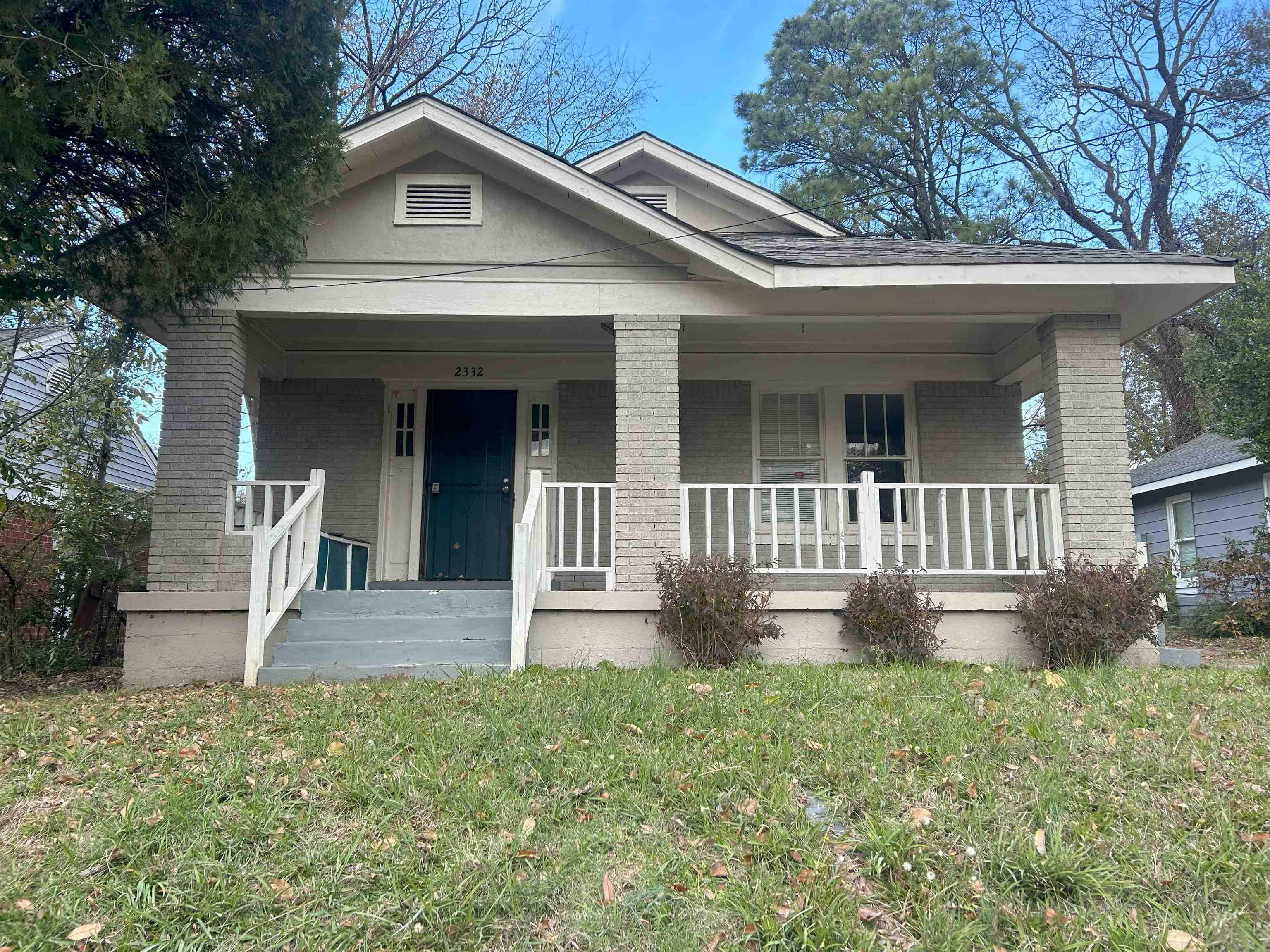 View of front of property with covered porch and a front lawn