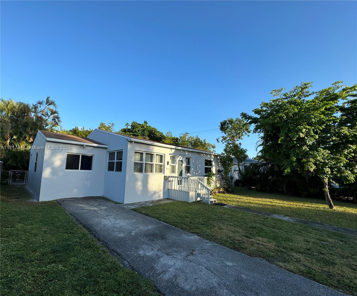 a front view of a house with a yard and trees