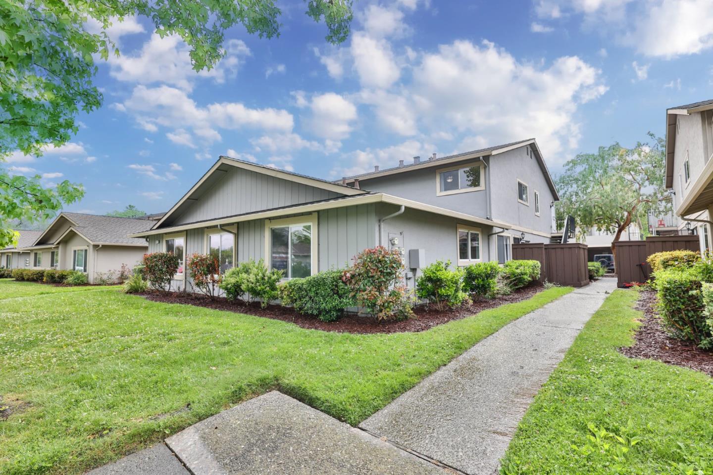 a front view of a house with a yard and potted plants