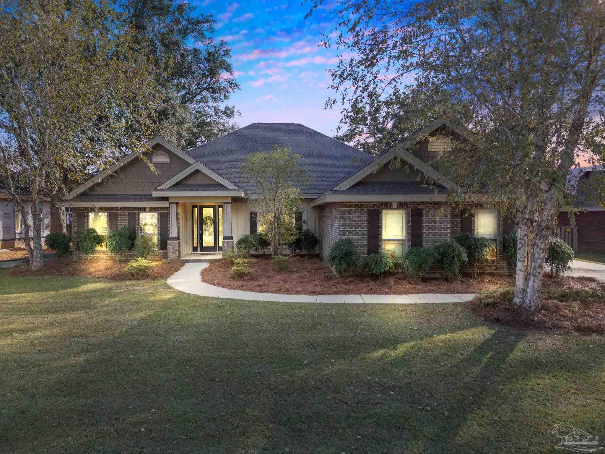 a front view of a house with yard and green space