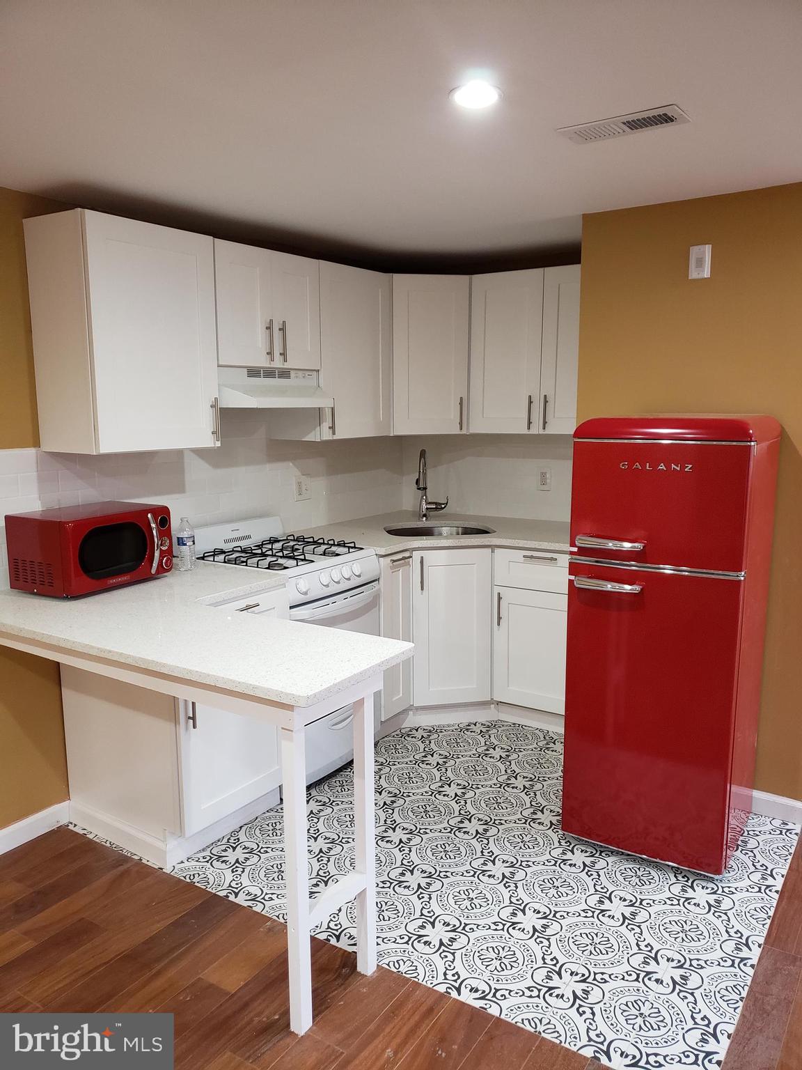 a kitchen with a sink a stove a refrigerator and cabinets