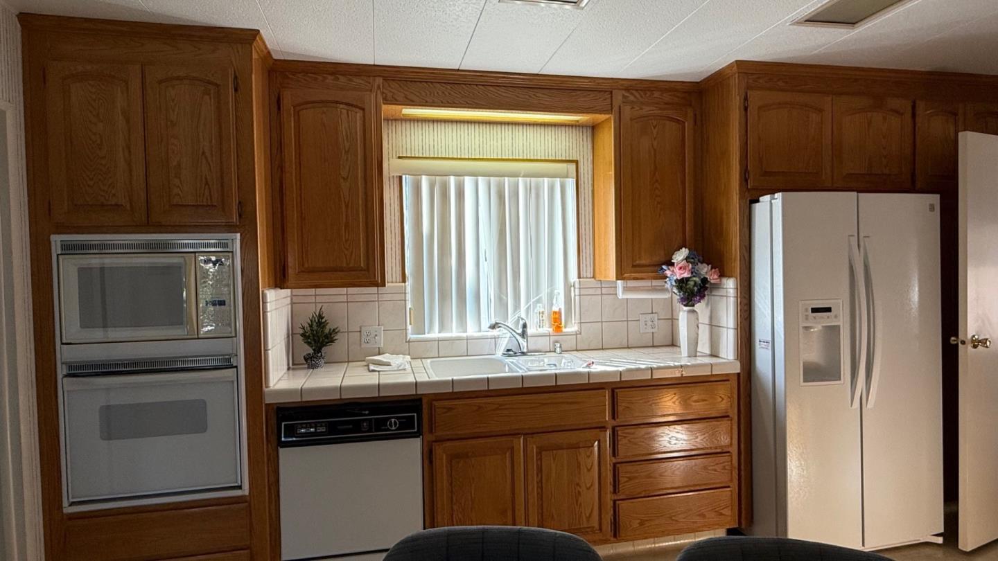 a kitchen with granite countertop a refrigerator and a sink