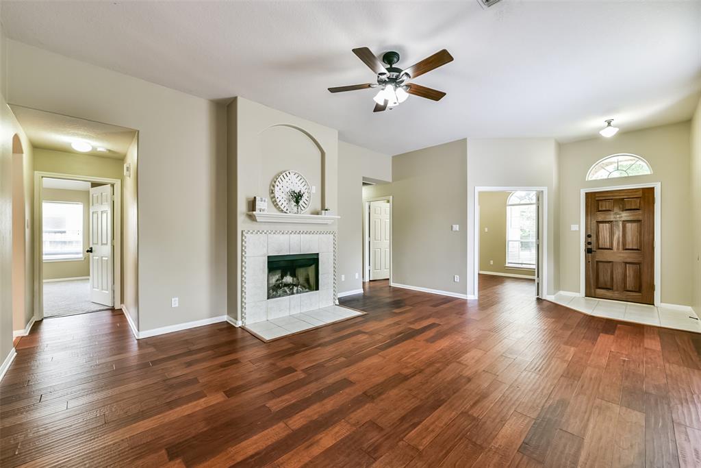 a view of a livingroom with wooden floor and a fireplace