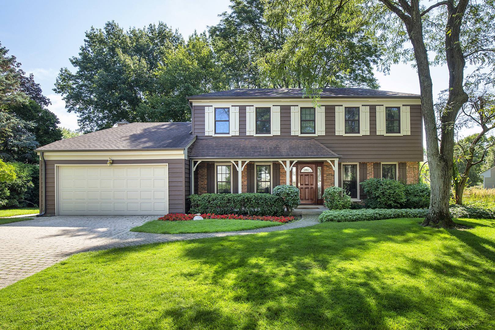 a front view of a house with a garden and yard