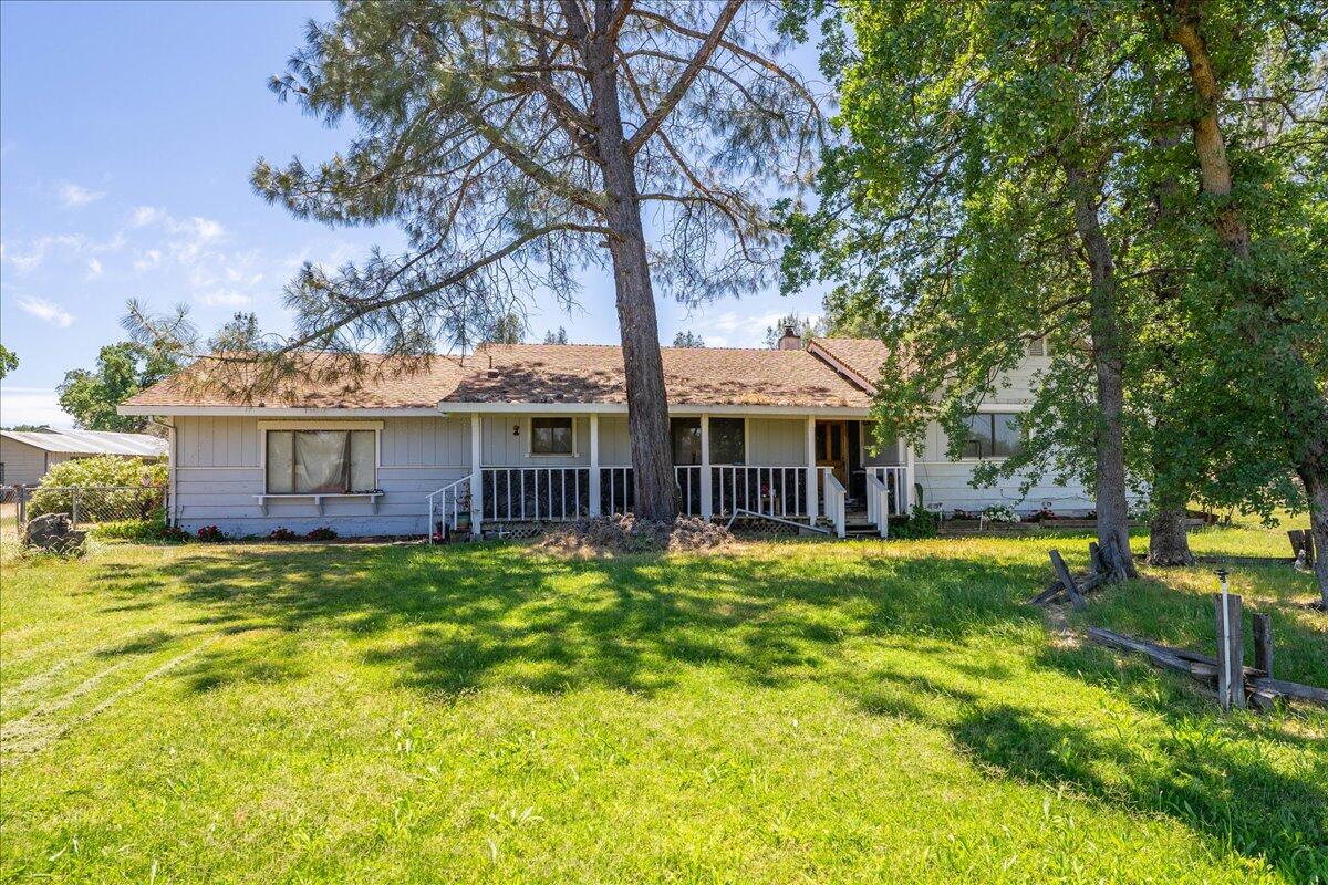 a view of a house with a big yard and large trees