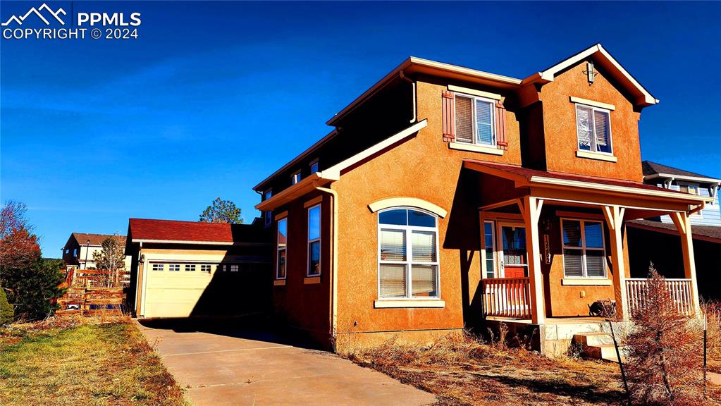 View of front of house with a porch and a garage