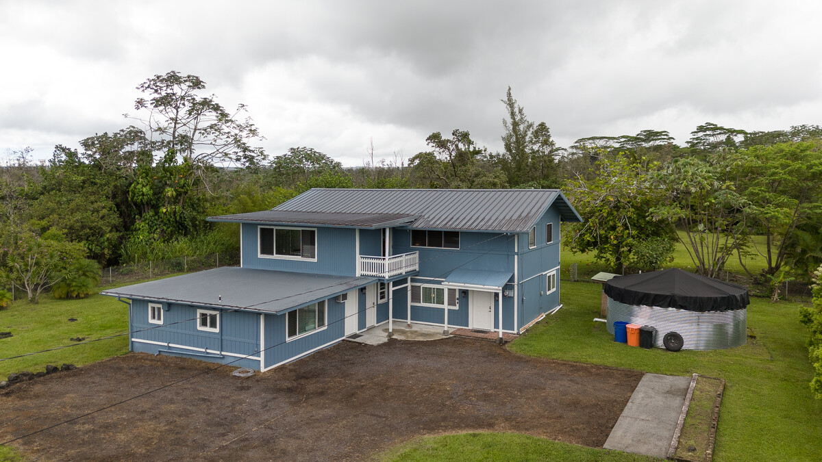 a aerial view of a house next to a yard