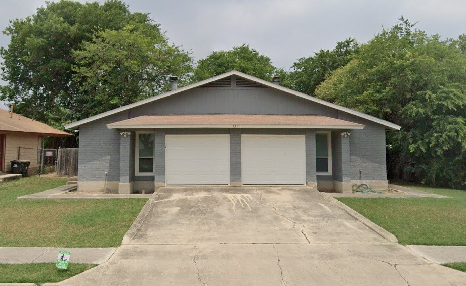 a front view of a house with yard and green space