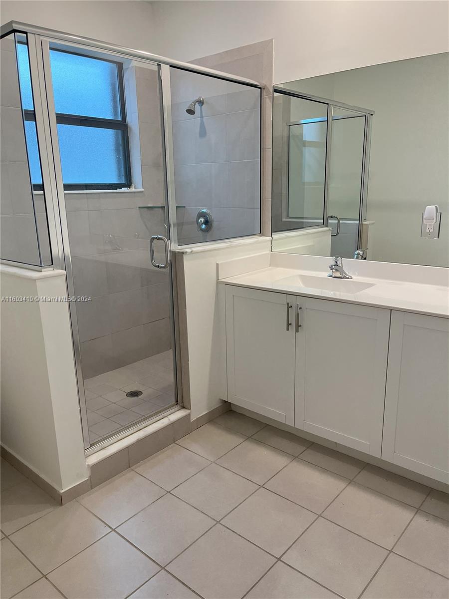 a bathroom with a shower sink and mirror