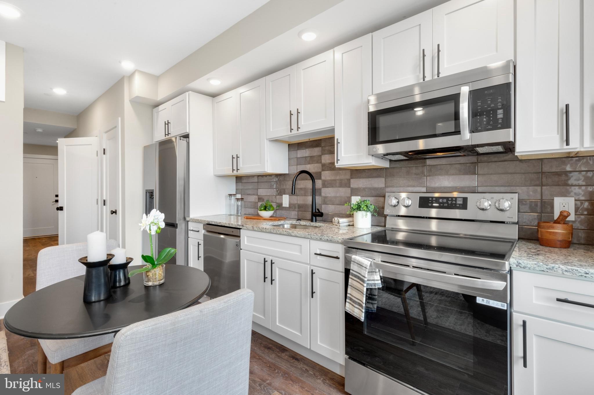 a kitchen with stainless steel appliances a stove a sink and a refrigerator