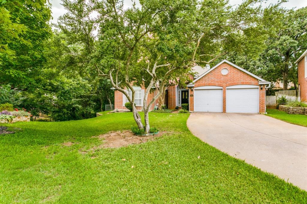 a front view of a house with a yard and trees