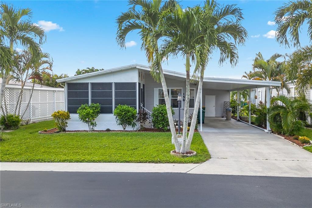 a front view of a house with a yard and palm trees