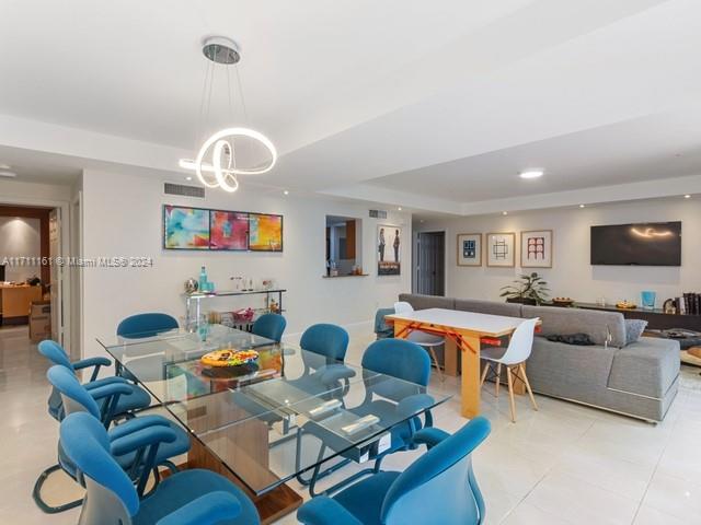 a living room with furniture kitchen view and a flat screen tv