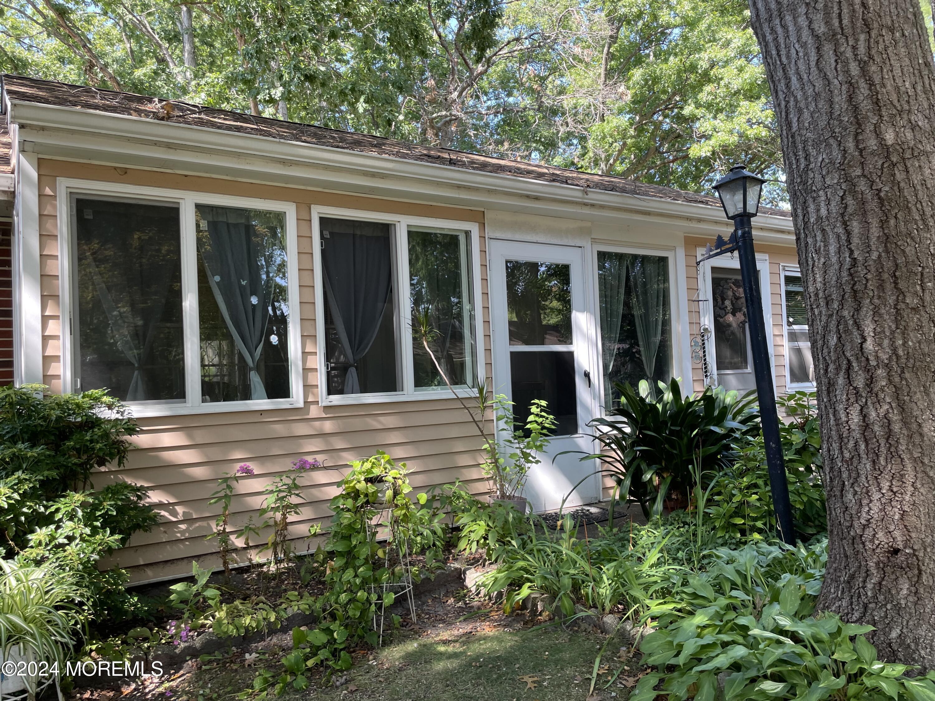 front view of a house with a large window and potted plants