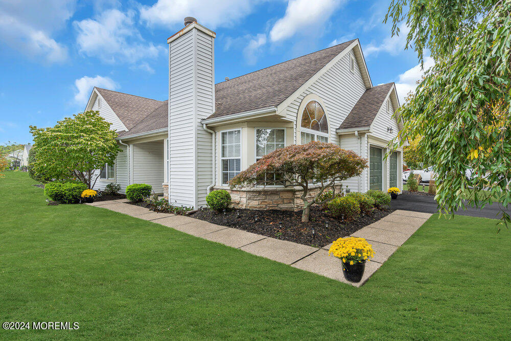 a front view of a house with a garden and yard