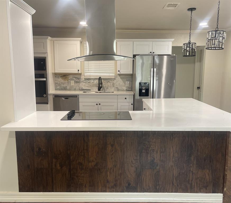 a kitchen with kitchen island a sink stainless steel appliances and cabinets