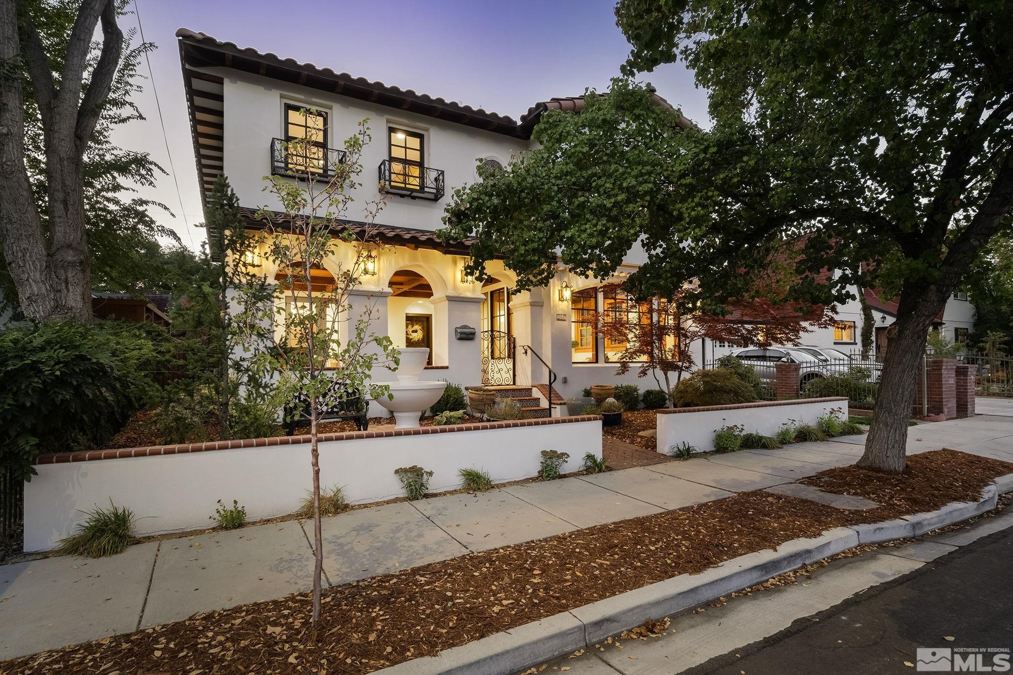 a front view of a house with trees and plants