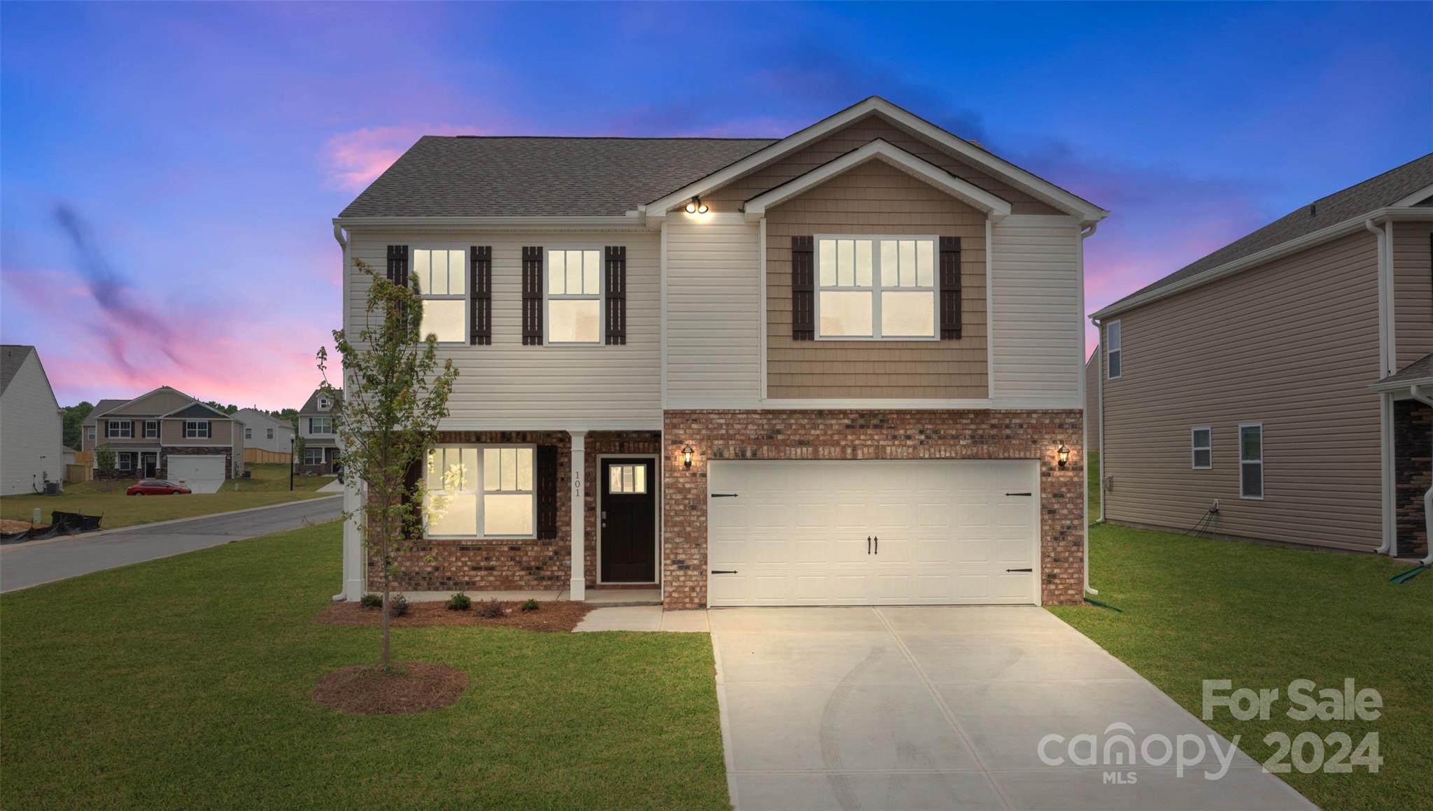 a front view of a house with a yard and garage