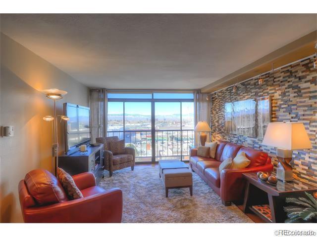 a living room with furniture a floor to ceiling window and a flat screen tv