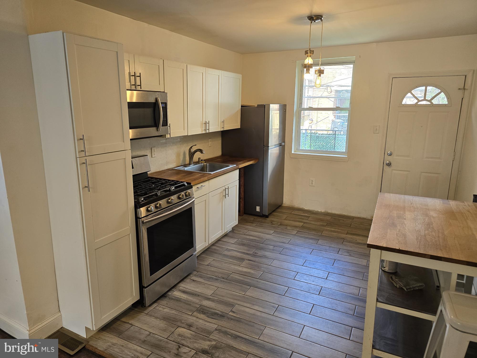 a kitchen with stainless steel appliances a stove microwave and sink