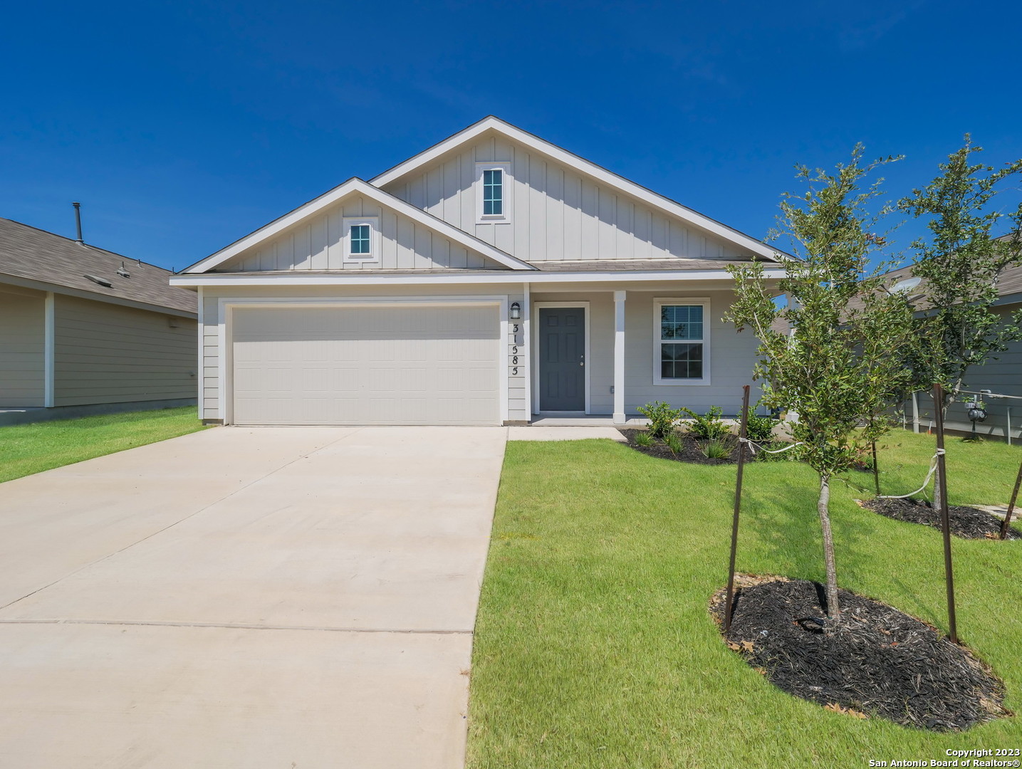 a front view of a house with a yard and trees