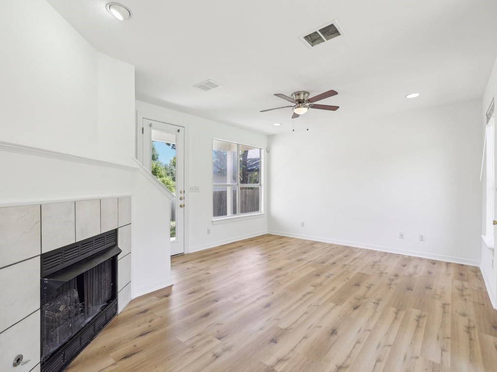 an empty room with a fireplace and wooden floor