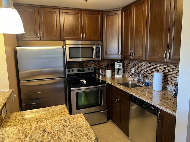 a kitchen with granite countertop a stove microwave and sink