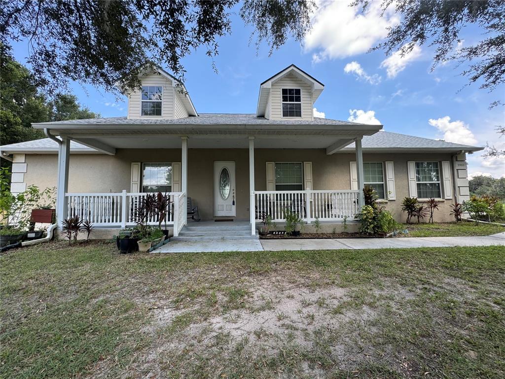 a view of a house with backyard porch and sitting area